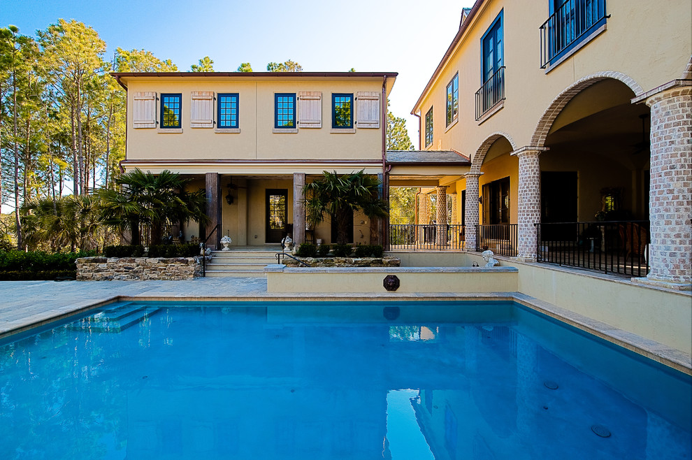 Imagen de piscina alargada tradicional grande rectangular en patio con adoquines de piedra natural