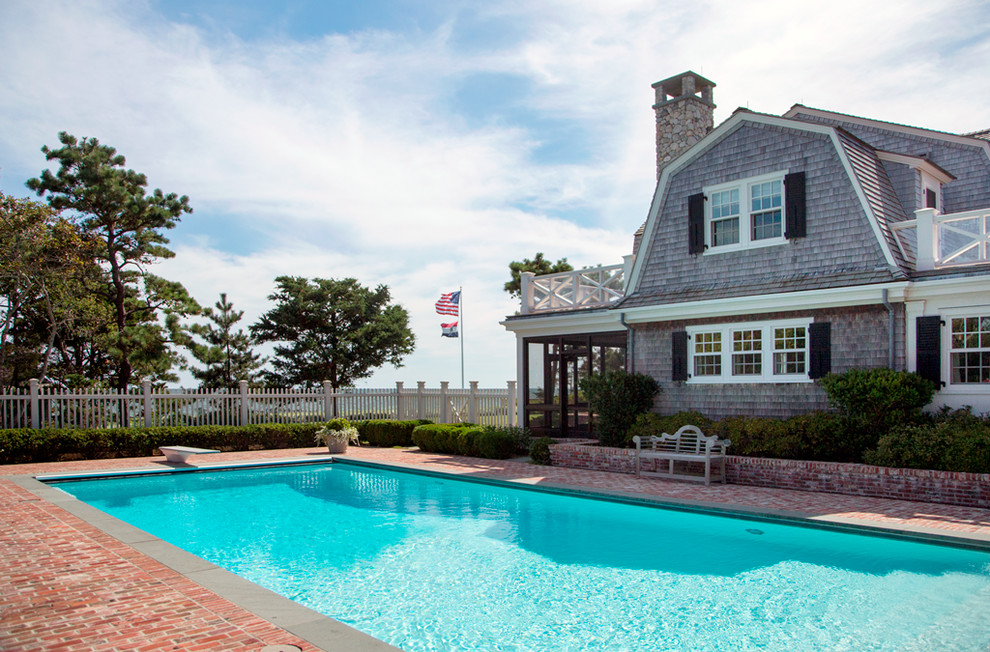 Ejemplo de piscina costera de tamaño medio rectangular en patio lateral con adoquines de ladrillo