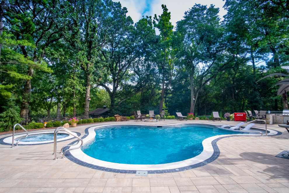 Bild på en mellanstor vintage anpassad pool på baksidan av huset, med spabad och naturstensplattor