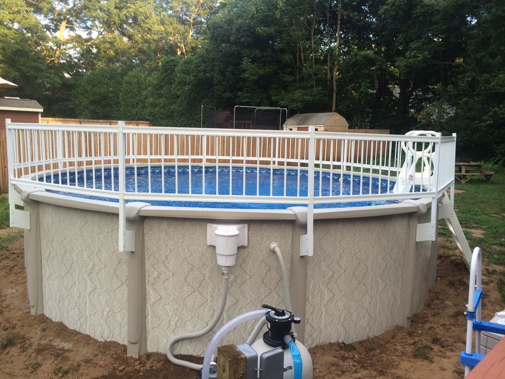 Diseño de piscina con fuente elevada redondeada en patio lateral con gravilla