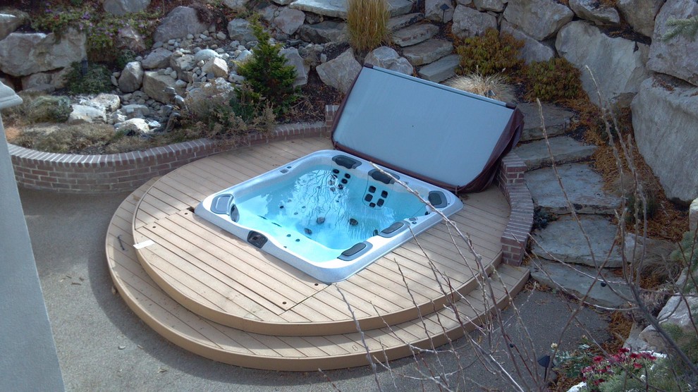 Modelo de piscinas y jacuzzis clásicos de tamaño medio en patio trasero con entablado