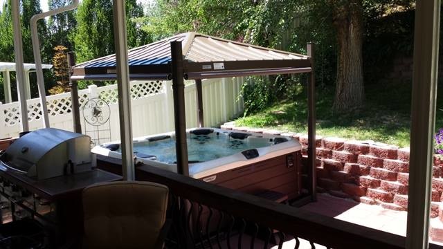 Aménagement d'une piscine arrière et hors-sol classique de taille moyenne avec un bain bouillonnant et une dalle de béton.