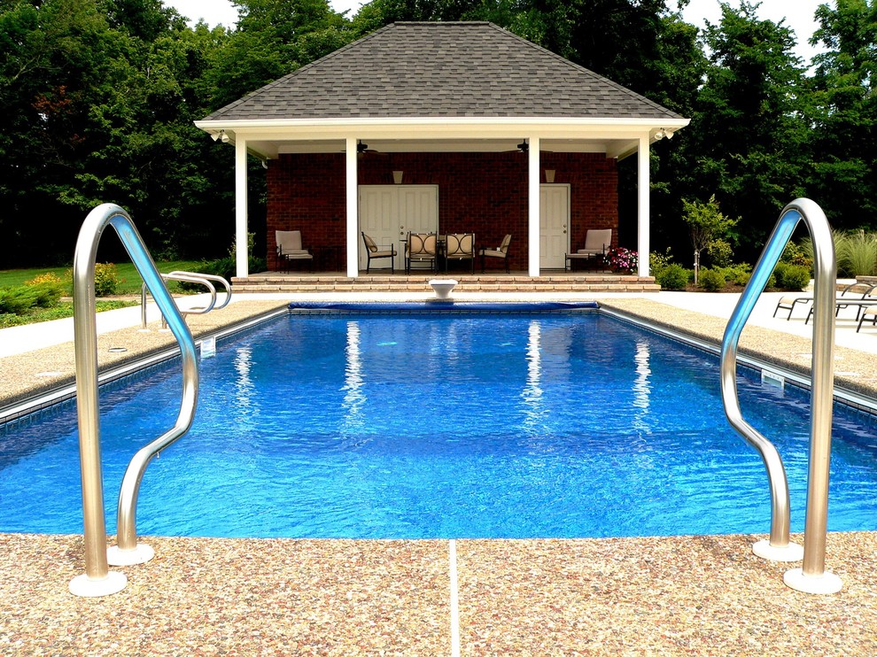 Cette image montre un grand Abris de piscine et pool houses arrière traditionnel rectangle avec une dalle de béton.