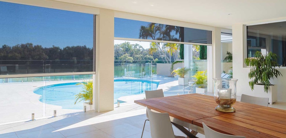 Großer Moderner Schwimmteich hinter dem Haus in individueller Form mit Natursteinplatten in Miami