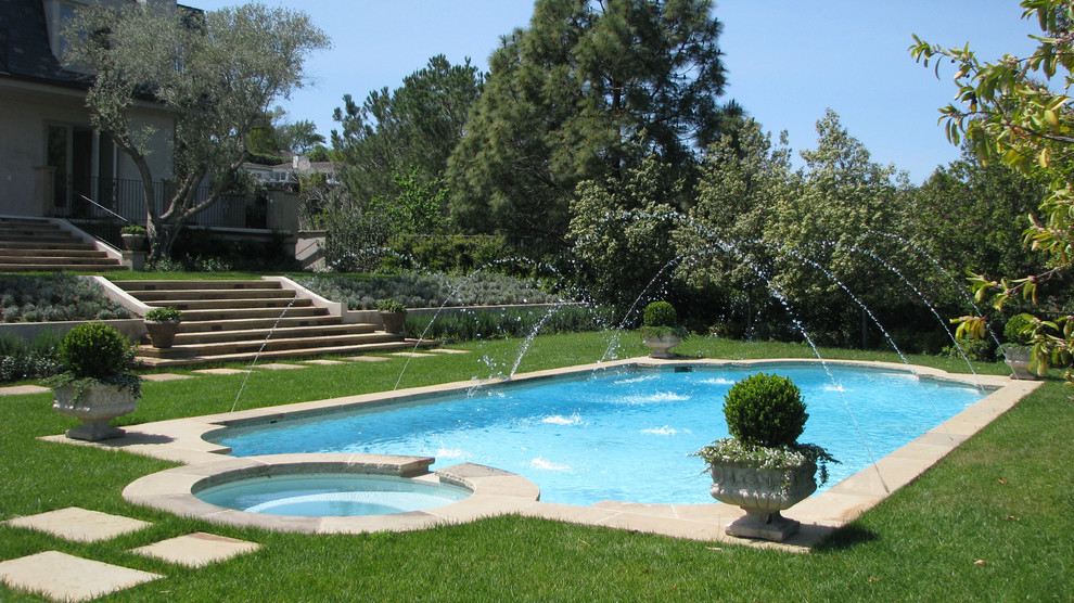 Foto de piscinas y jacuzzis alargados clásicos grandes a medida en patio trasero con adoquines de piedra natural