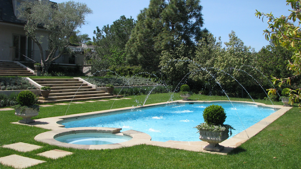 This is an example of a large traditional back custom shaped lengths hot tub in Orange County with natural stone paving.