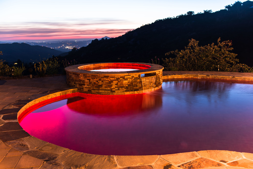 Ispirazione per una grande piscina naturale contemporanea personalizzata dietro casa con una vasca idromassaggio e pavimentazioni in pietra naturale