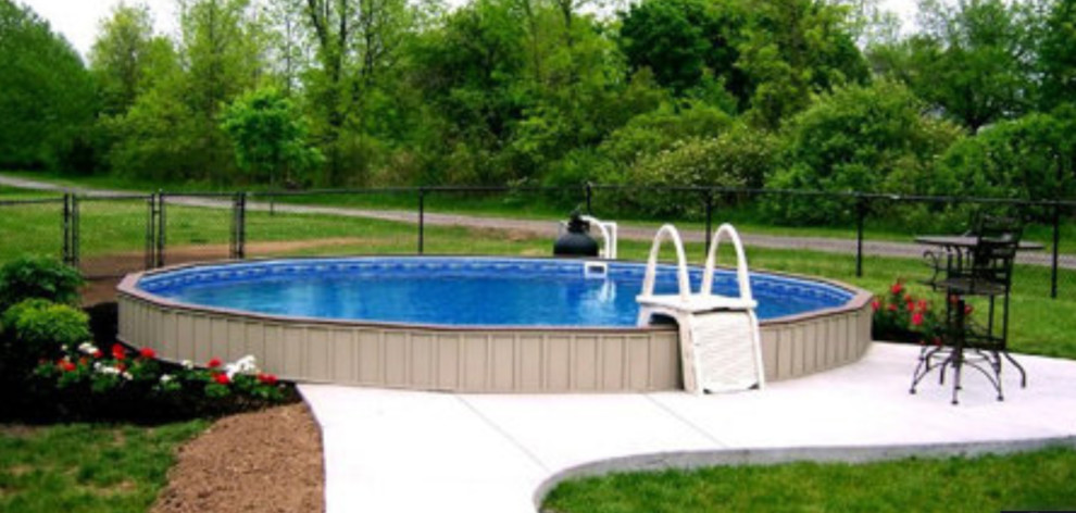 На фото: наземный, круглый бассейн среднего размера на заднем дворе в классическом стиле с мощением тротуарной плиткой с