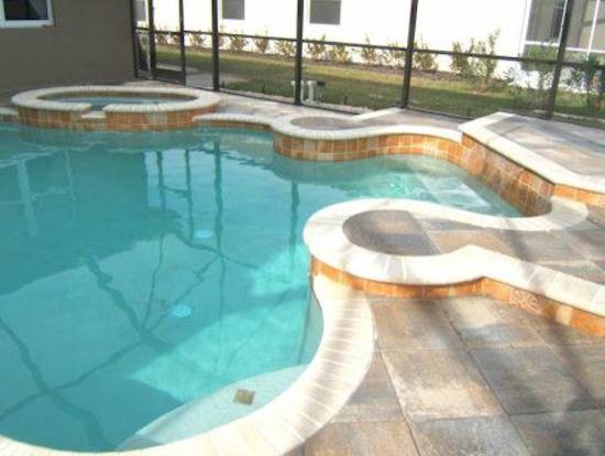 Modelo de piscinas y jacuzzis clásicos renovados pequeños a medida en patio trasero con adoquines de hormigón