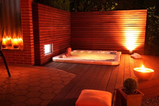 Inspiration for a medium sized modern back above ground hot tub in Houston with a shelter and decking.