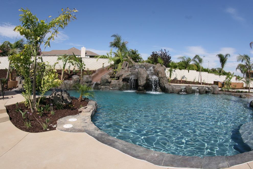 Esempio di una piscina monocorsia minimal personalizzata di medie dimensioni e dietro casa con fontane e lastre di cemento