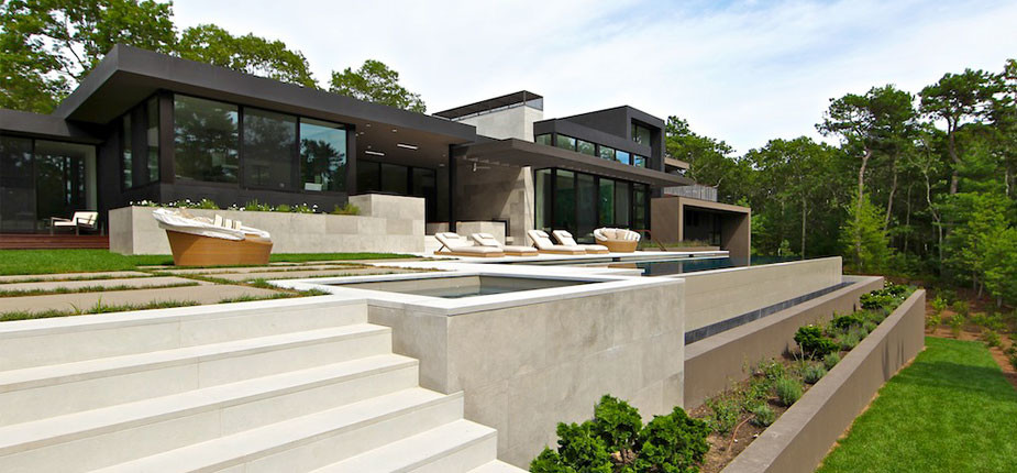 Immagine di una grande piscina a sfioro infinito moderna rettangolare dietro casa con una vasca idromassaggio e pavimentazioni in pietra naturale