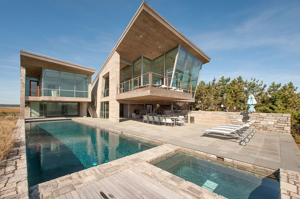 Inspiration för en funkis rektangulär pool på baksidan av huset, med spabad och naturstensplattor