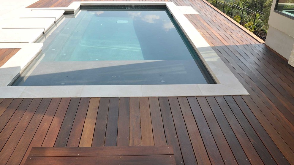 Immagine di una piscina naturale minimal rettangolare di medie dimensioni e dietro casa con pedane