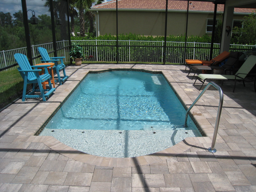 Foto de piscina clásica de tamaño medio a medida en patio trasero con losas de hormigón