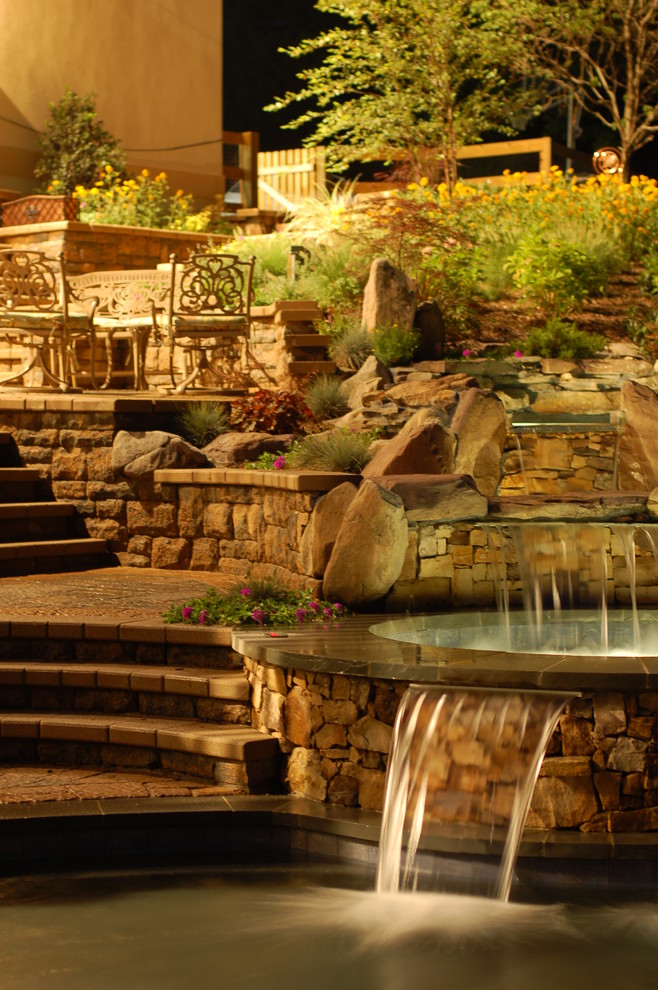 Foto di una piscina naturale tradizionale personalizzata di medie dimensioni e dietro casa con fontane e pavimentazioni in mattoni