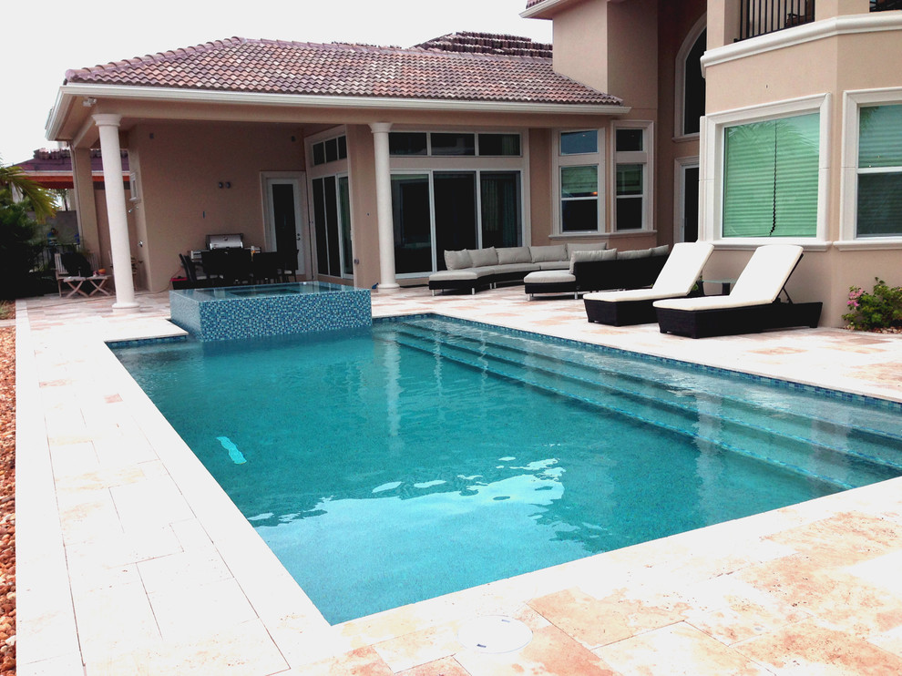 Großes Modernes Sportbecken hinter dem Haus in rechteckiger Form mit Wasserspiel in Miami