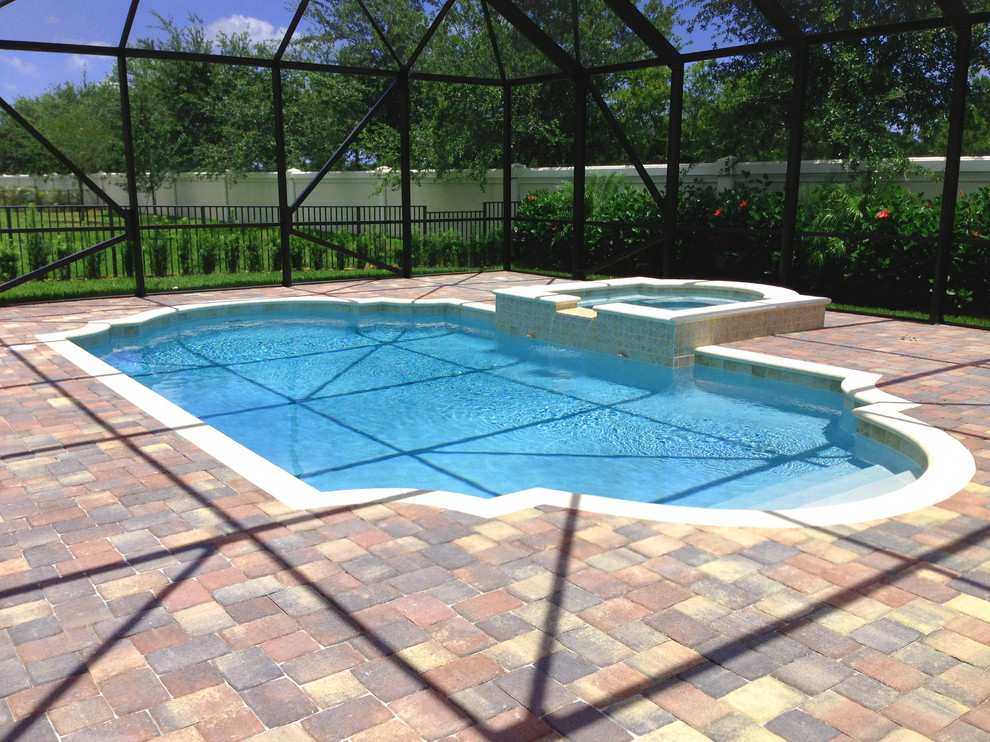 Foto de piscina con fuente alargada clásica renovada de tamaño medio a medida en patio trasero con adoquines de ladrillo