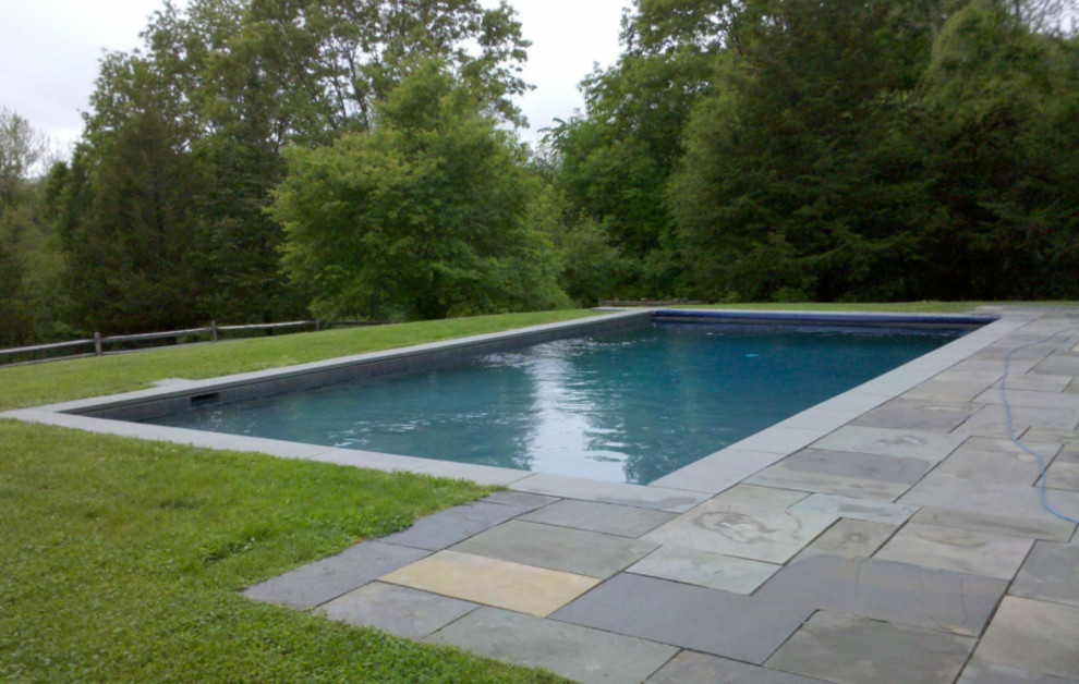 Pool - large traditional backyard stone and rectangular pool idea in New York