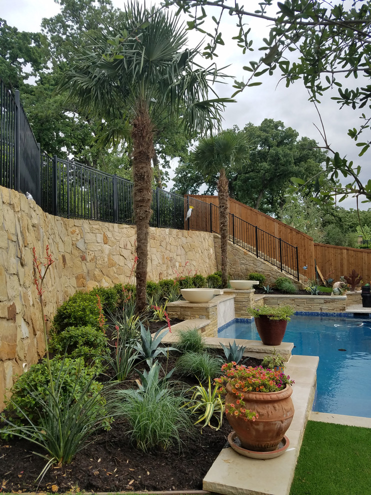 Mid-sized elegant backyard concrete paver and rectangular lap pool fountain photo in Dallas