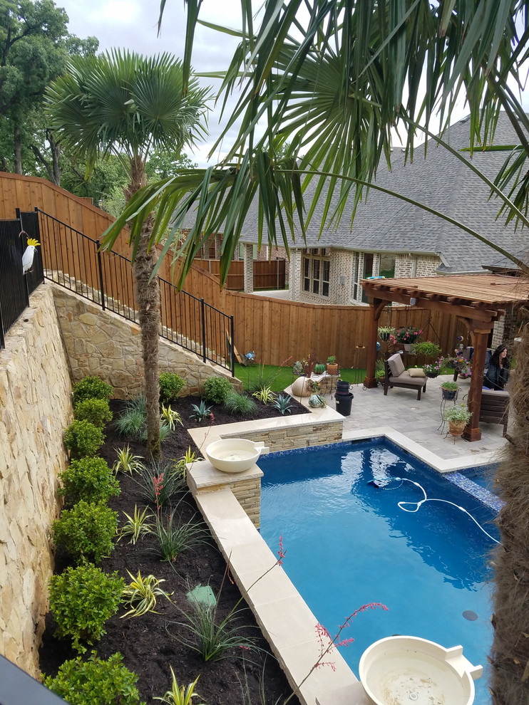 Foto de piscina con fuente alargada tradicional de tamaño medio rectangular en patio trasero con adoquines de hormigón