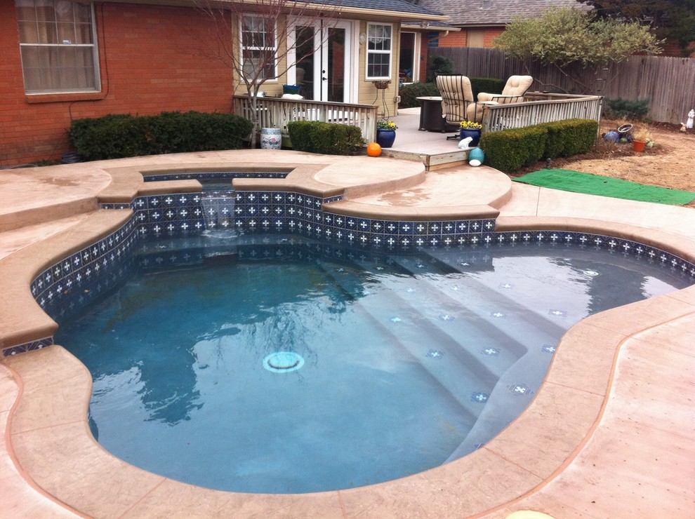 Esempio di una piscina monocorsia tropicale di medie dimensioni e dietro casa con una vasca idromassaggio