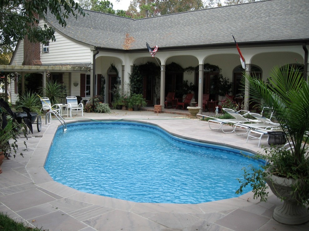 Foto de piscina tradicional de tamaño medio en patio lateral con adoquines de piedra natural