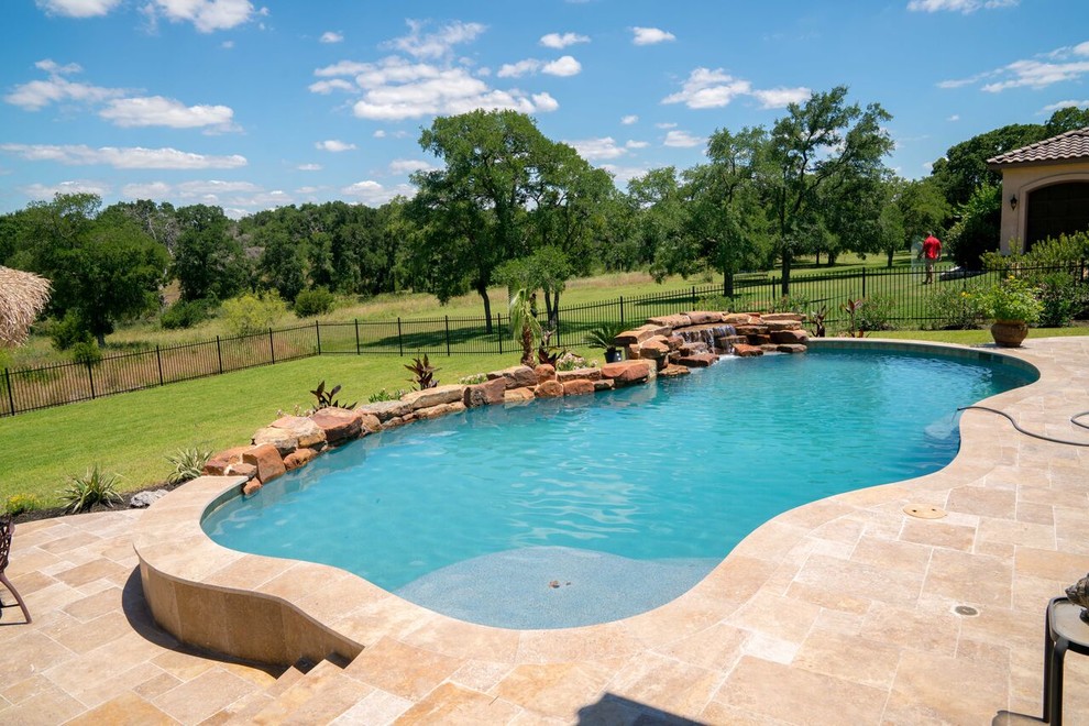 На фото: большой бассейн произвольной формы на заднем дворе в классическом стиле с фонтаном и покрытием из плитки