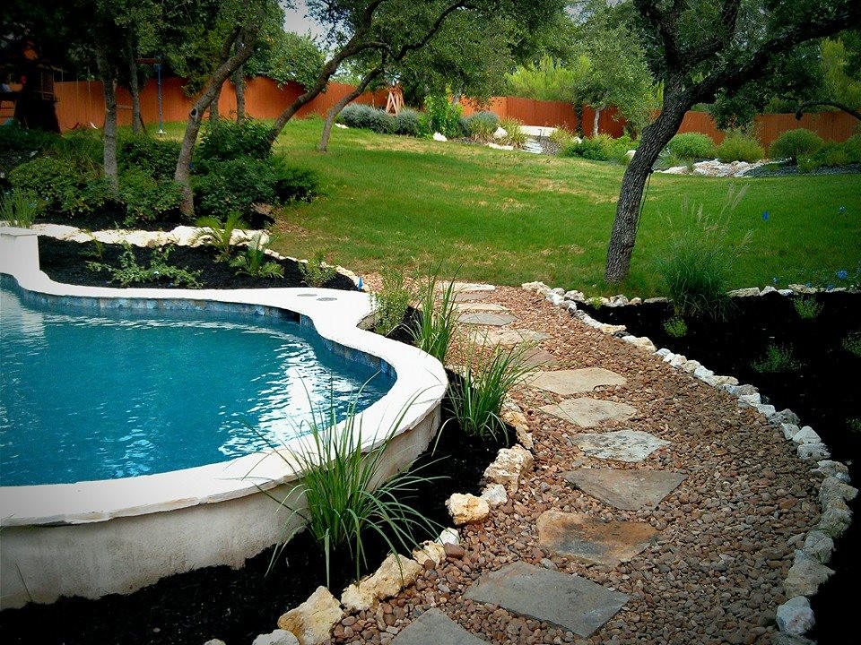 Diseño de piscina clásica de tamaño medio a medida en patio trasero con gravilla