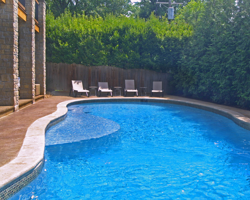Mittelgroßer Mediterraner Pool hinter dem Haus in individueller Form mit Wasserrutsche und Natursteinplatten in St. Louis