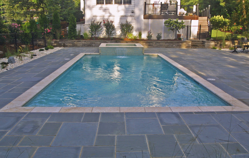 Ejemplo de piscinas y jacuzzis alargados modernos de tamaño medio rectangulares en patio trasero con adoquines de hormigón