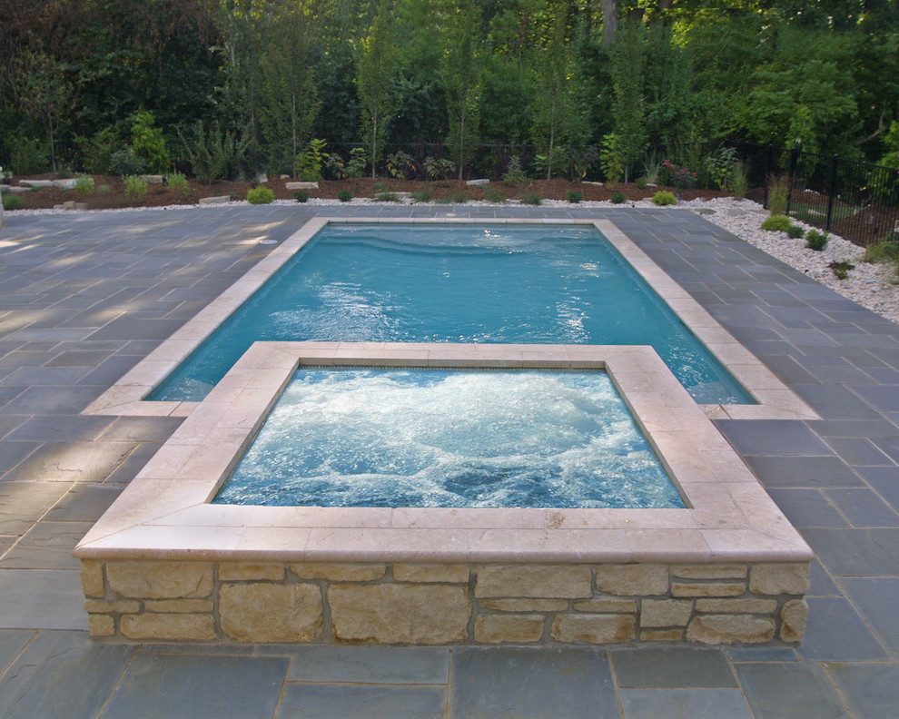 Diseño de piscinas y jacuzzis alargados minimalistas de tamaño medio rectangulares en patio trasero con adoquines de hormigón