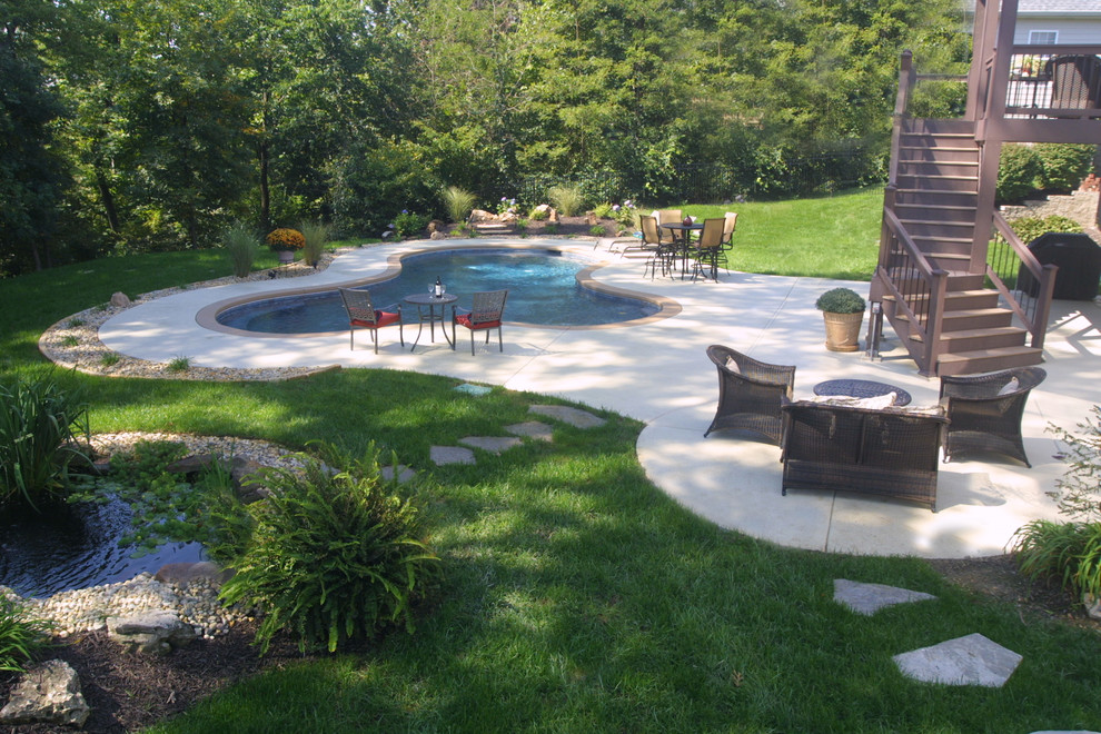 Photo of a medium sized traditional back custom shaped lengths swimming pool in St Louis with concrete slabs.