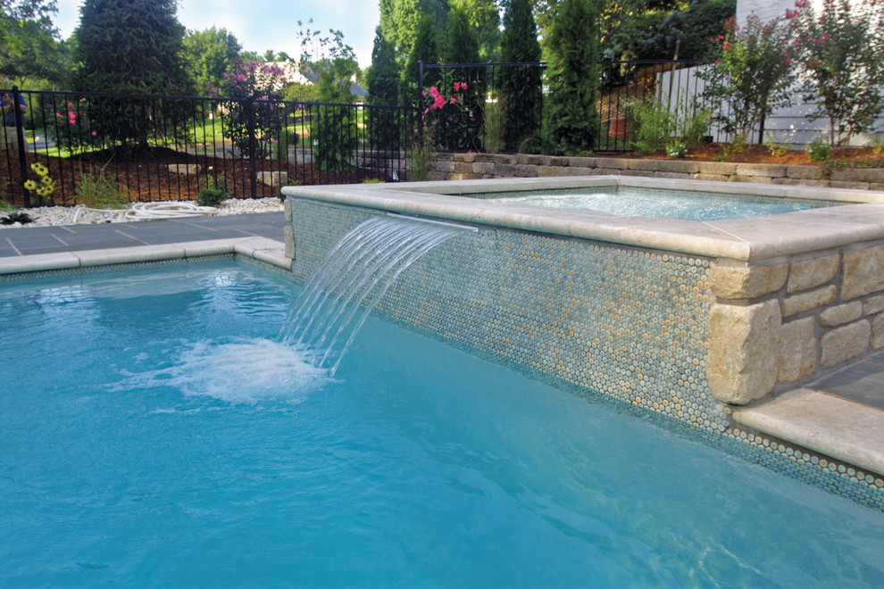 Esempio di una piscina monocorsia mediterranea rettangolare di medie dimensioni e dietro casa con una vasca idromassaggio e pavimentazioni in cemento
