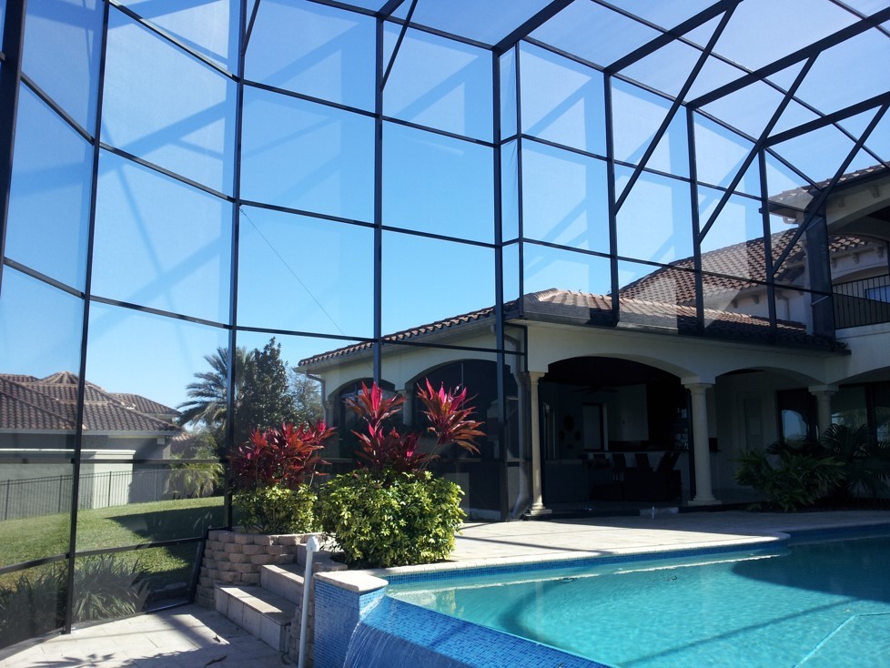 Diseño de casa de la piscina y piscina elevada actual grande rectangular en patio trasero con losas de hormigón