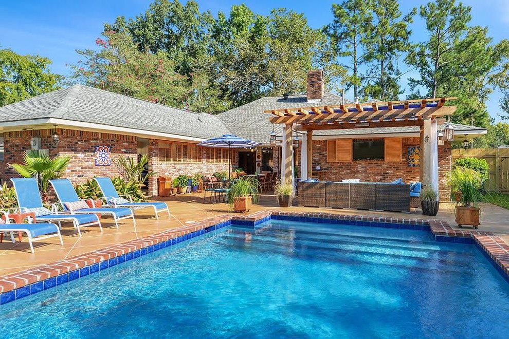 Diseño de piscina alargada tradicional de tamaño medio rectangular en patio trasero con suelo de baldosas