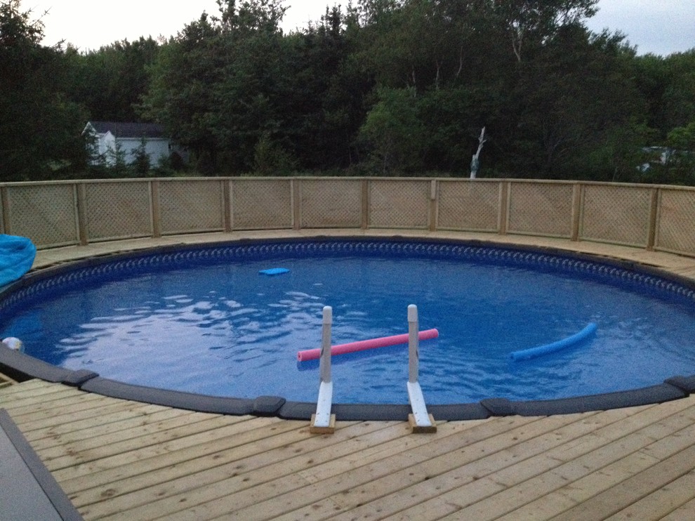 Ispirazione per una piscina fuori terra classica rotonda di medie dimensioni e dietro casa con pedane
