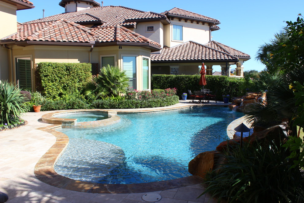 Esempio di una piscina a sfioro infinito tropicale personalizzata di medie dimensioni e dietro casa con pavimentazioni in pietra naturale