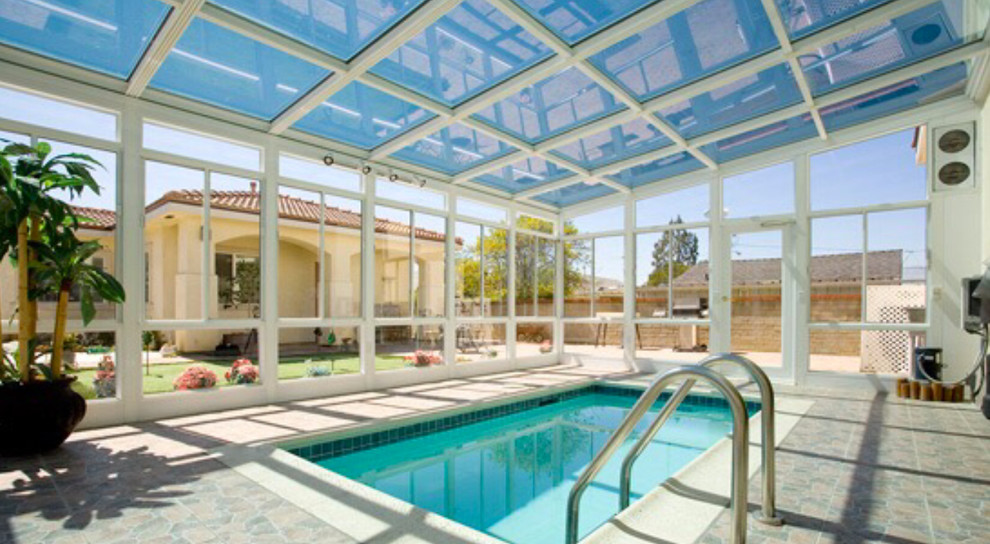Esempio di una piscina coperta classica rettangolare di medie dimensioni con pavimentazioni in cemento