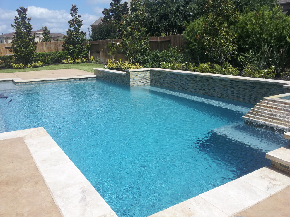 Design ideas for a l-shaped swimming pool in Houston with stamped concrete.