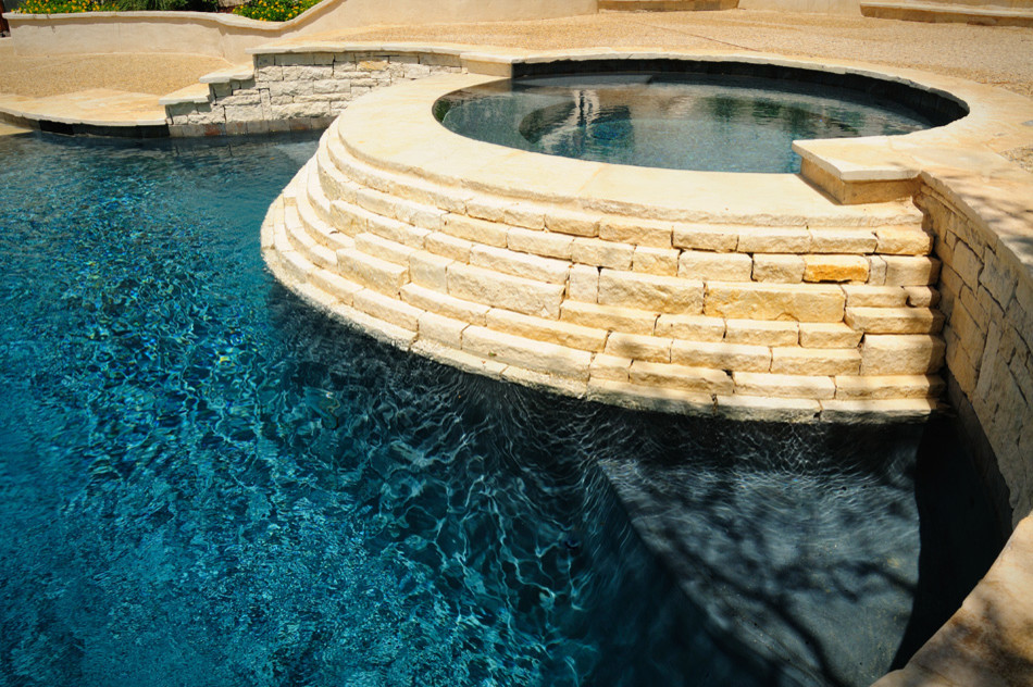 Foto di una piscina monocorsia chic personalizzata di medie dimensioni e dietro casa con una vasca idromassaggio e pavimentazioni in pietra naturale