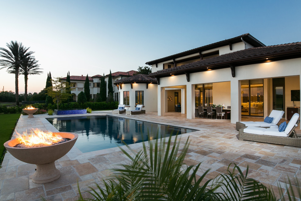 Diseño de piscinas y jacuzzis infinitos mediterráneos grandes rectangulares en patio trasero con adoquines de piedra natural
