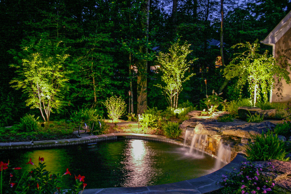 На фото: большой естественный бассейн произвольной формы на заднем дворе в стиле неоклассика (современная классика) с фонтаном и мощением тротуарной плиткой с