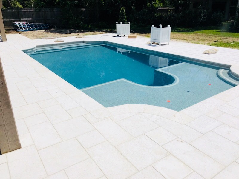 Ispirazione per una piscina a sfioro infinito minimal rettangolare di medie dimensioni e dietro casa con fontane e pavimentazioni in mattoni
