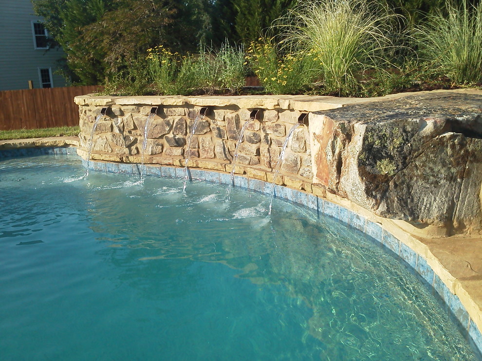 Klassischer Pool hinter dem Haus in individueller Form mit Wasserspiel und Natursteinplatten in Atlanta