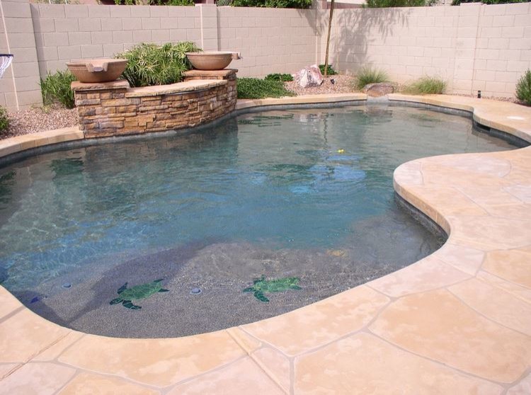 Immagine di una piscina naturale stile marinaro personalizzata di medie dimensioni e dietro casa con fontane e cemento stampato