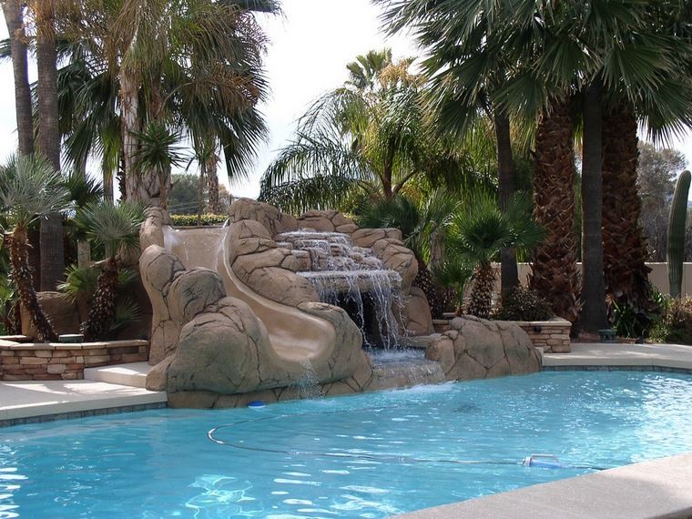 Esempio di una piscina naturale design personalizzata di medie dimensioni e dietro casa con un acquascivolo e lastre di cemento