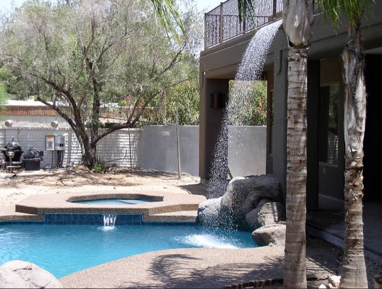 Esempio di una piscina naturale classica personalizzata di medie dimensioni e dietro casa con fontane e cemento stampato