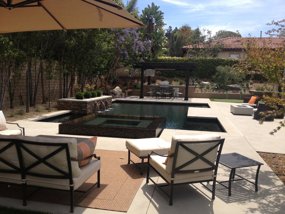 Diseño de piscinas y jacuzzis alargados actuales de tamaño medio rectangulares en patio trasero