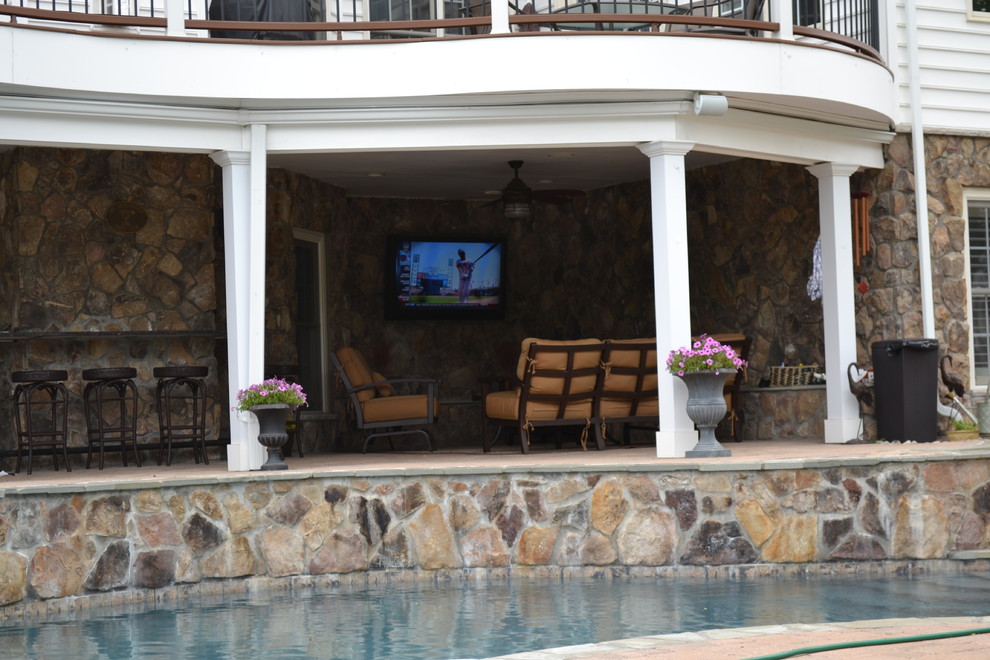 Foto di una piscina monocorsia minimal a "C" di medie dimensioni e dietro casa con una vasca idromassaggio e pavimentazioni in pietra naturale